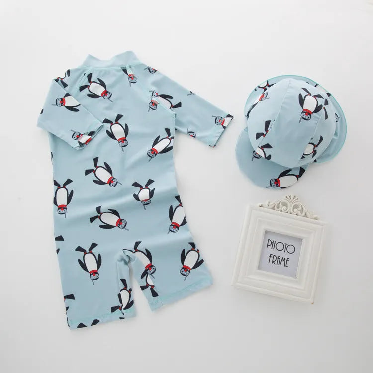 Boy's blue penguin print long sleeve swimsuit top and shorts with matching swimming cap.