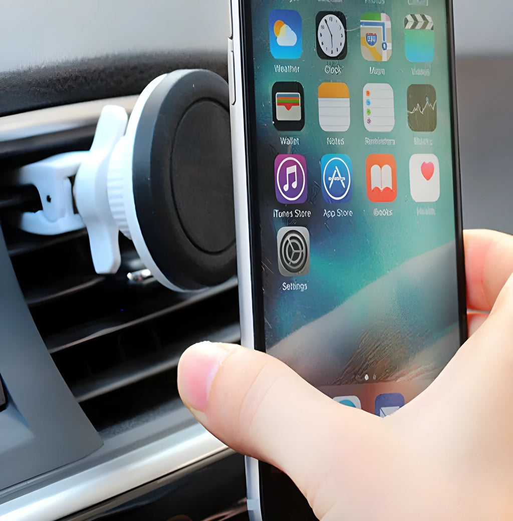 Black magnetic car phone holder mounted on vehicle dashboard with smartphone attached