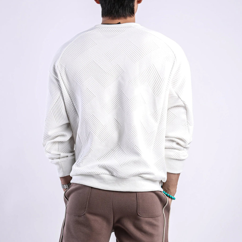 Man wearing a loose-fit, solid-colour twill jacquard long-sleeved sweater with a round neck.