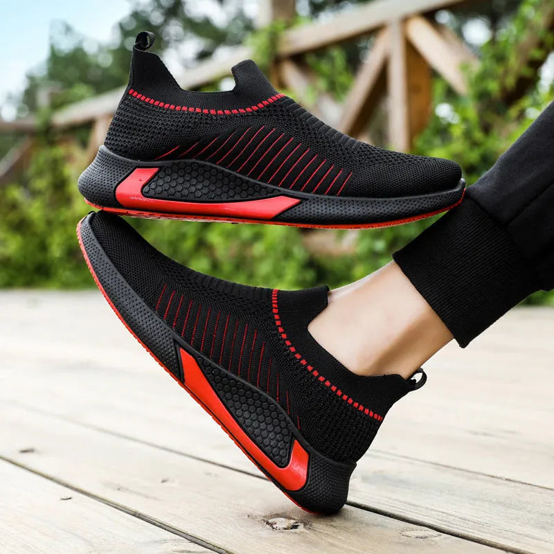 Men's black and white mesh slip-on sneakers with striped design and flat sole.
