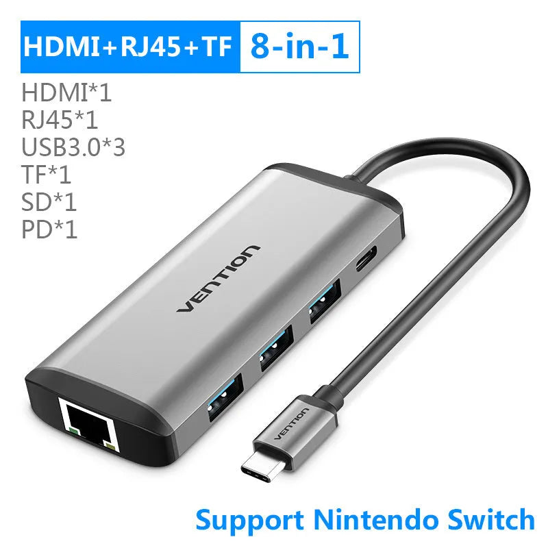 Deep grey USB-C to 8-in-1 hub with HDMI, USB ports, Ethernet, card slots, and a short cable on a desk.