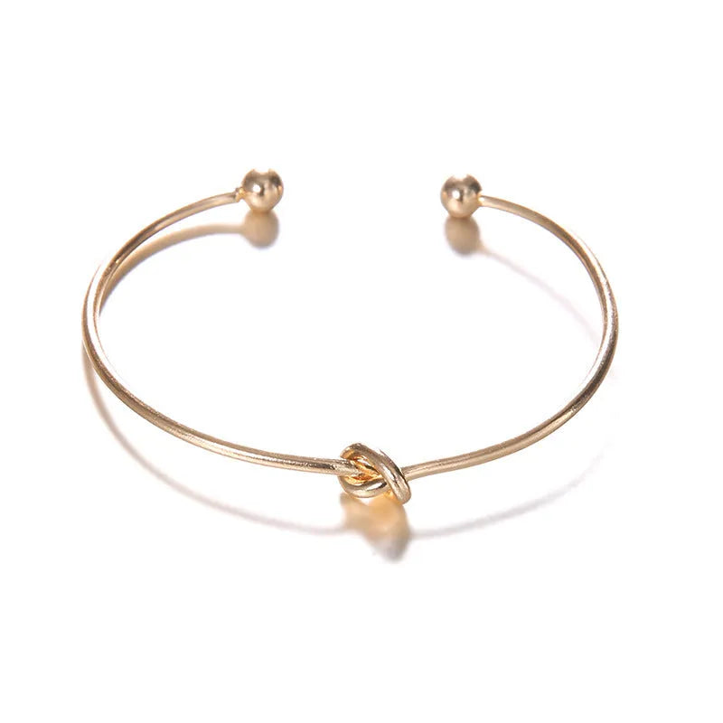 Women's vintage cuff bracelet with arrow and knotted design in gold electroplated alloy