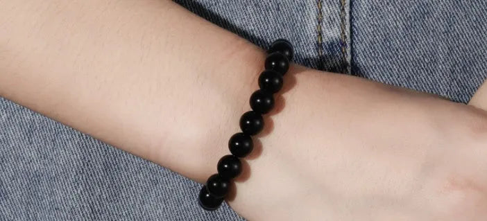 A geometric black agate bead stretch bracelet with 8mm stones on an elastic cord.