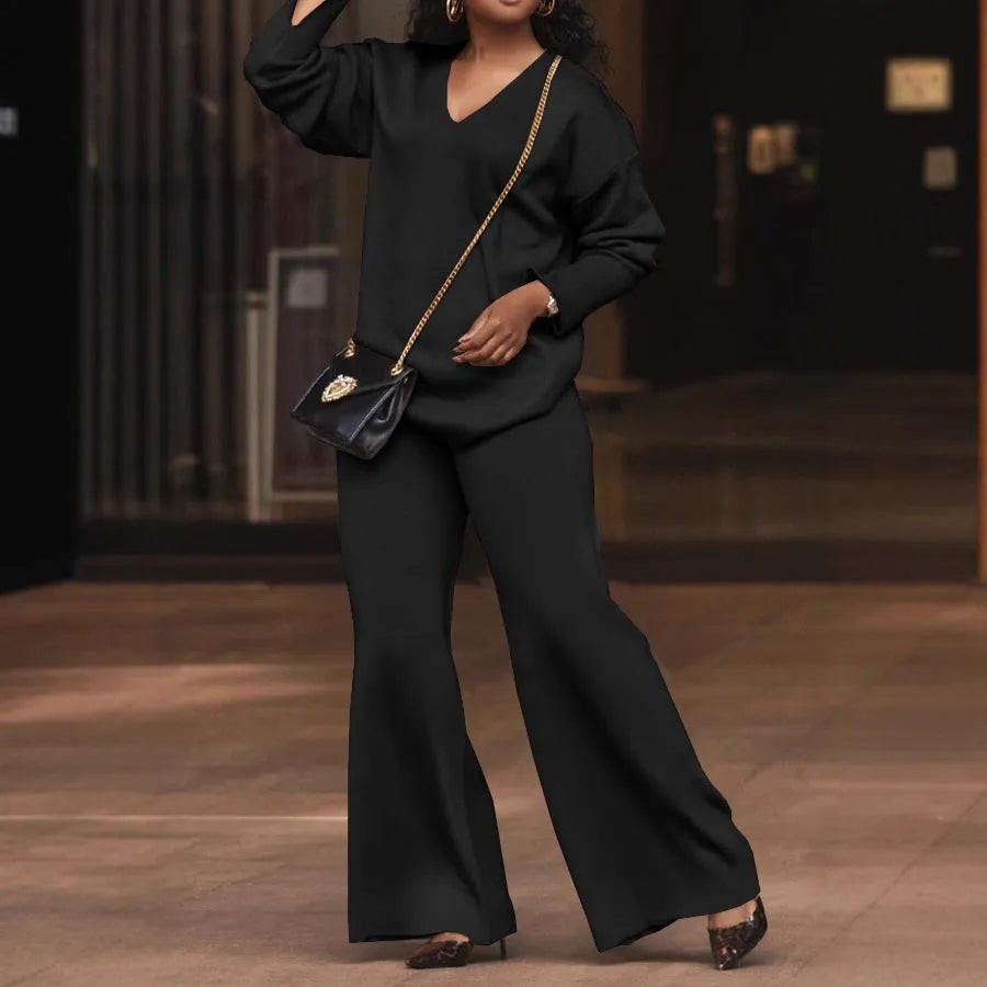 Women's brown suede two-piece suit with split sleeve top and matching trousers laid flat