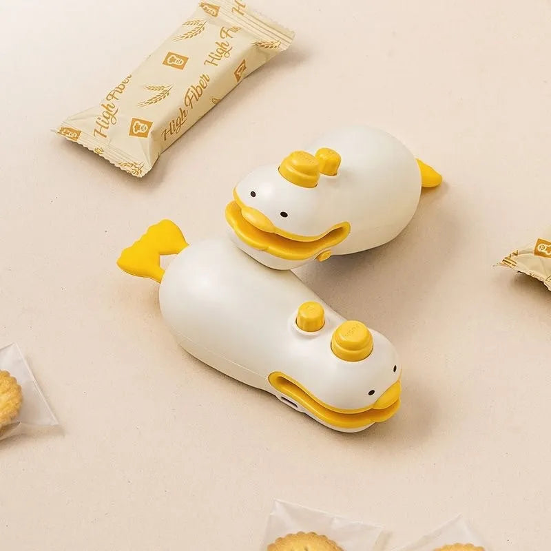 Small yellow duck animal jacquard style rechargeable handheld plastic bag sealing machine with charging cable.