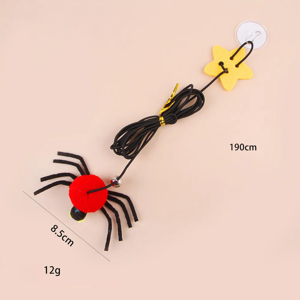 Red and yellow hanging cat toy with elastic rope, feathers, and a bell spider attached to a door.