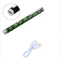 Set of three green laser pointer pens in black, camouflage, and white colours on a desk.