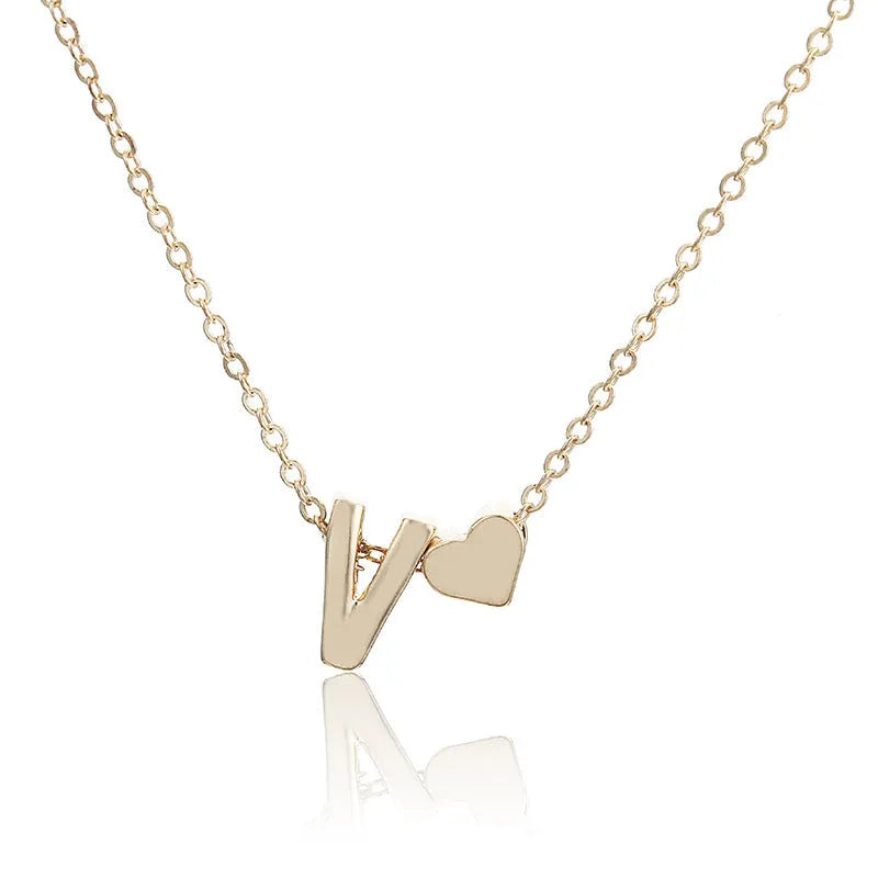 Gold alloy peach heart-shaped pendant with a single letter charm on a silver chain.