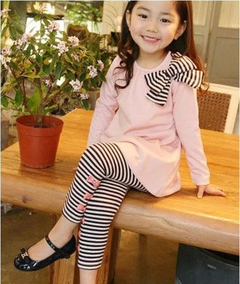 Pink cotton two-piece clothing set for a girl, shown on a hanger.