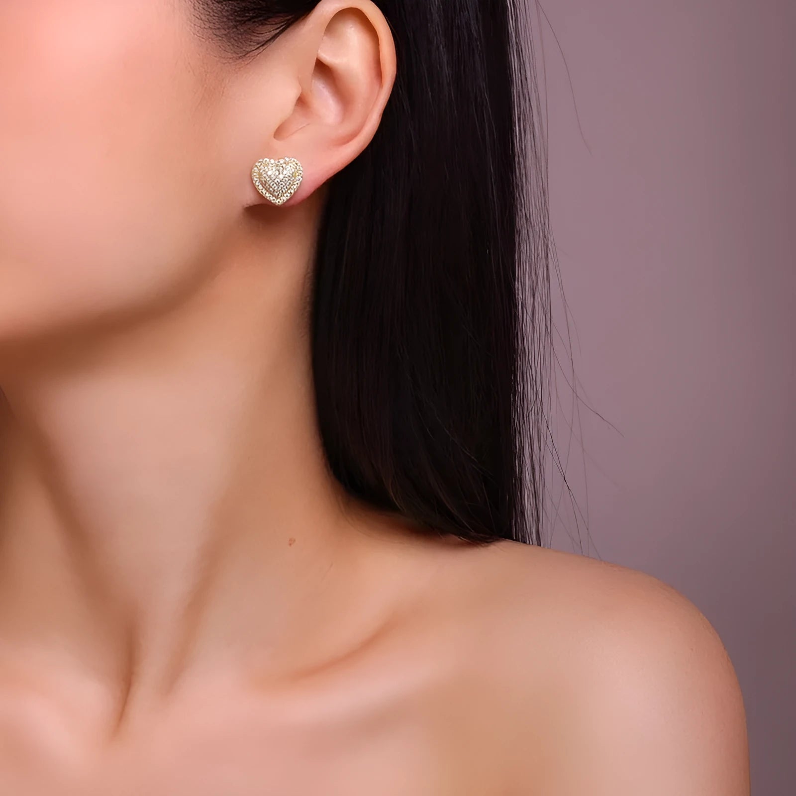 A pair of gold-coloured S925 sterling silver heart stud earrings with moissanite stones.