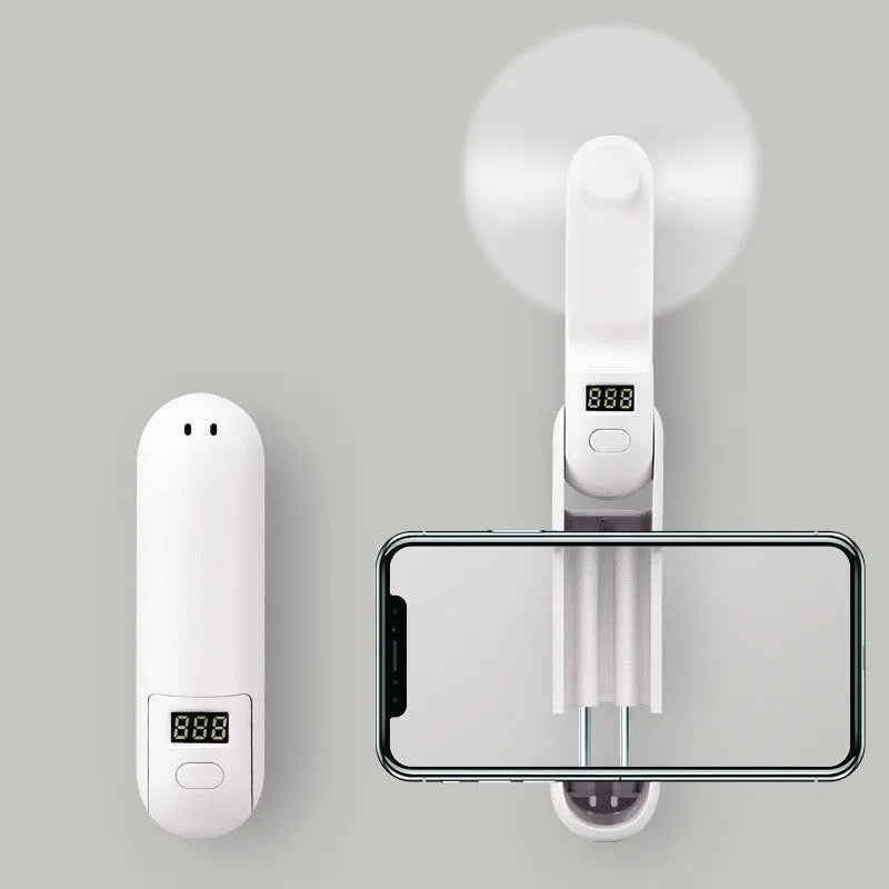 Green folding mini portable fan with USB cable on a white desk