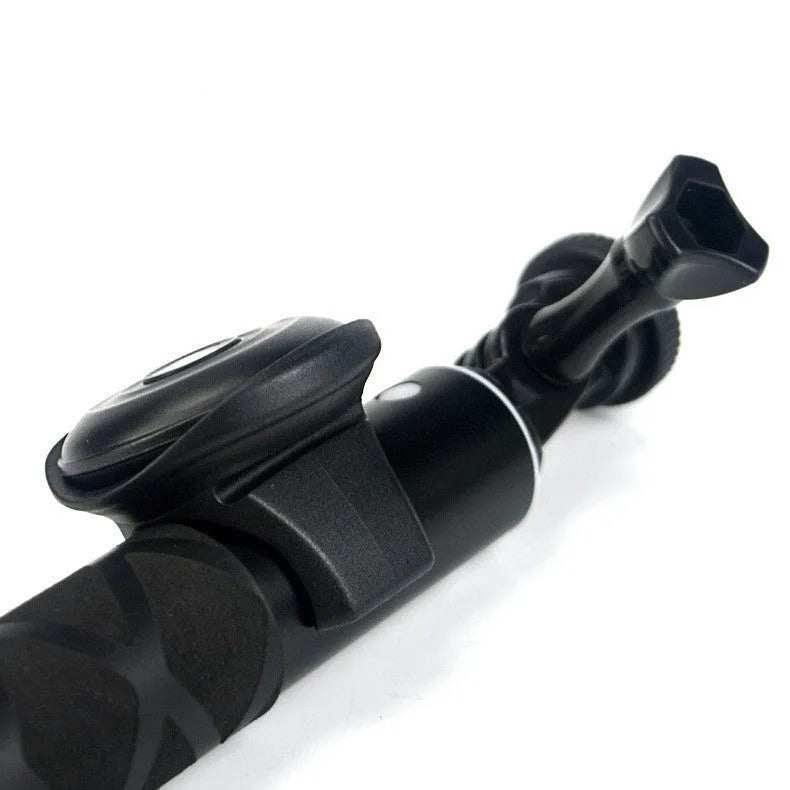 Black Bluetooth remote shutter release for smartphone camera on a white background.