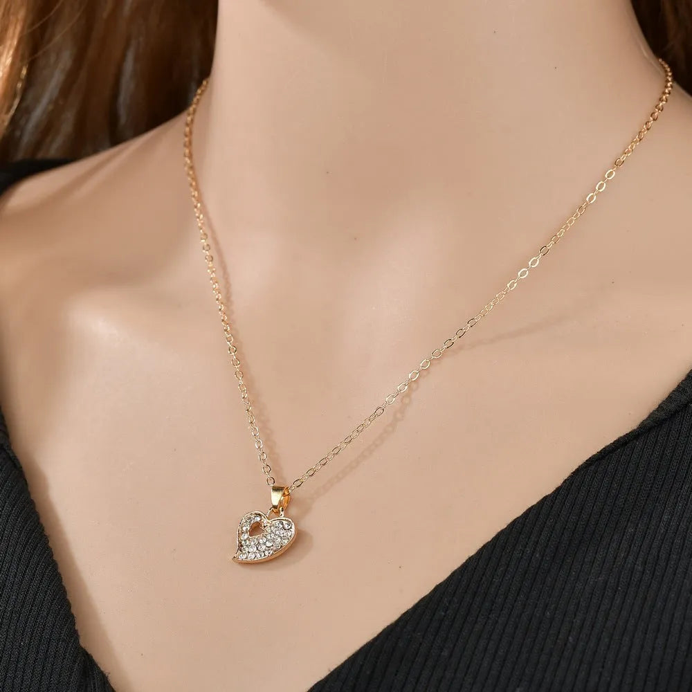 Gold-colour alloy jewellery set with earrings, pendant, and bracelet featuring love and bell patterns
