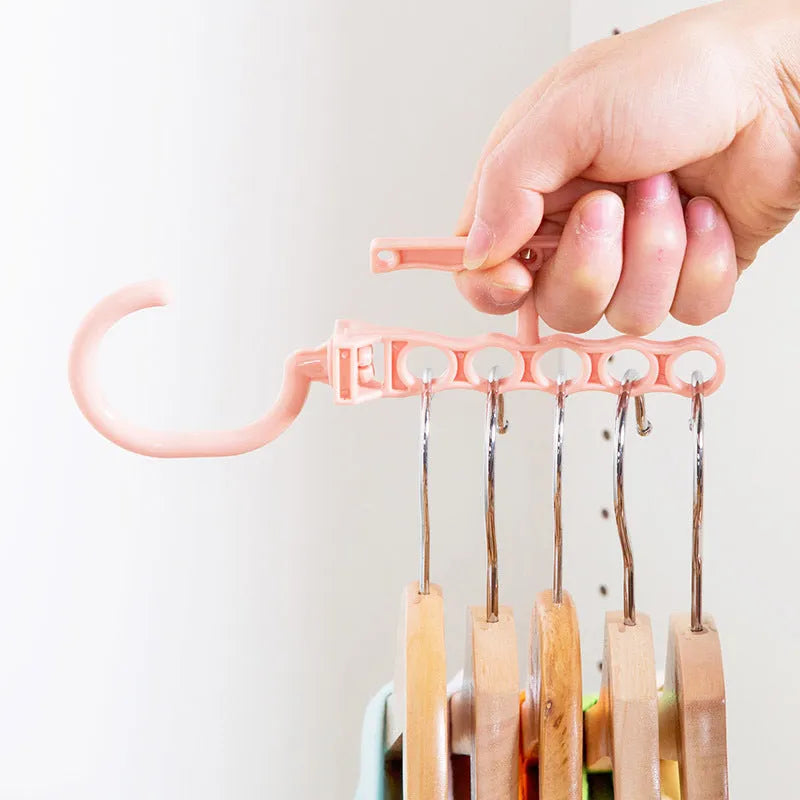 Blue magic revolving wardrobe hanger with five holes and a central handle on a white background.