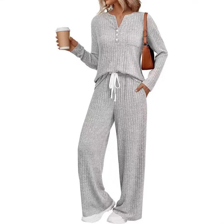 Woman wearing a striped V-neck knit long coat with lace-up detail and pants from a casual streetwear set.