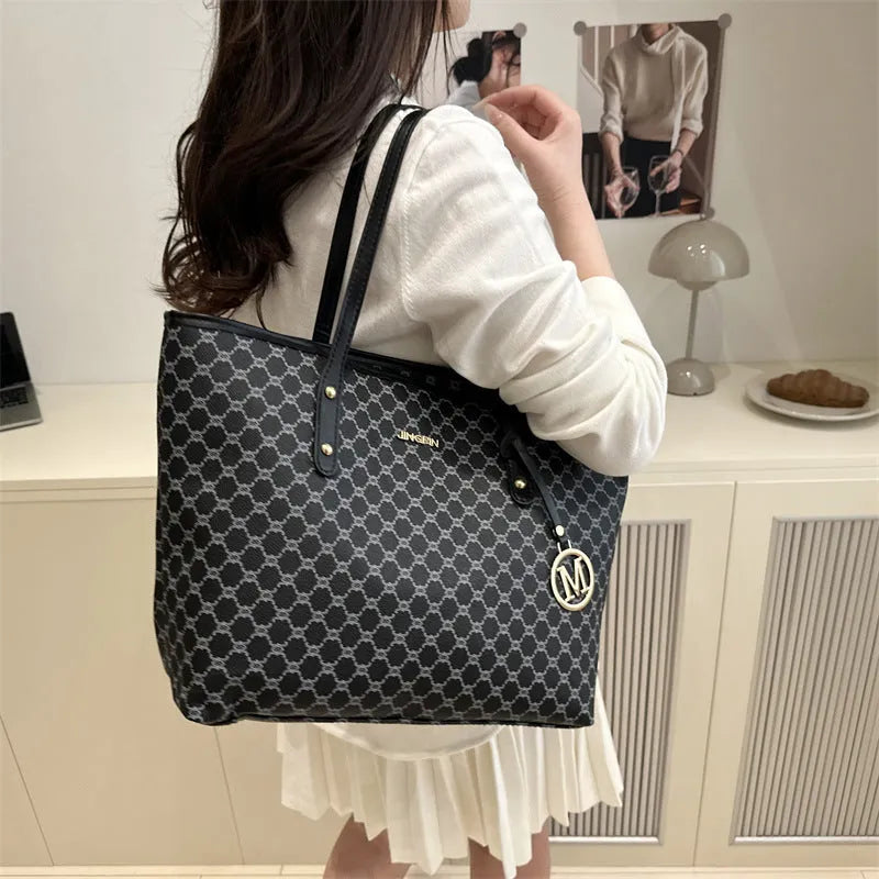 Structured black PU leather shoulder bag with adjustable strap and visible sewing thread detailing