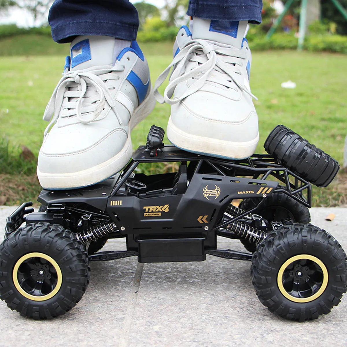Large black 4WD remote control climbing car on rough terrain with wireless controller