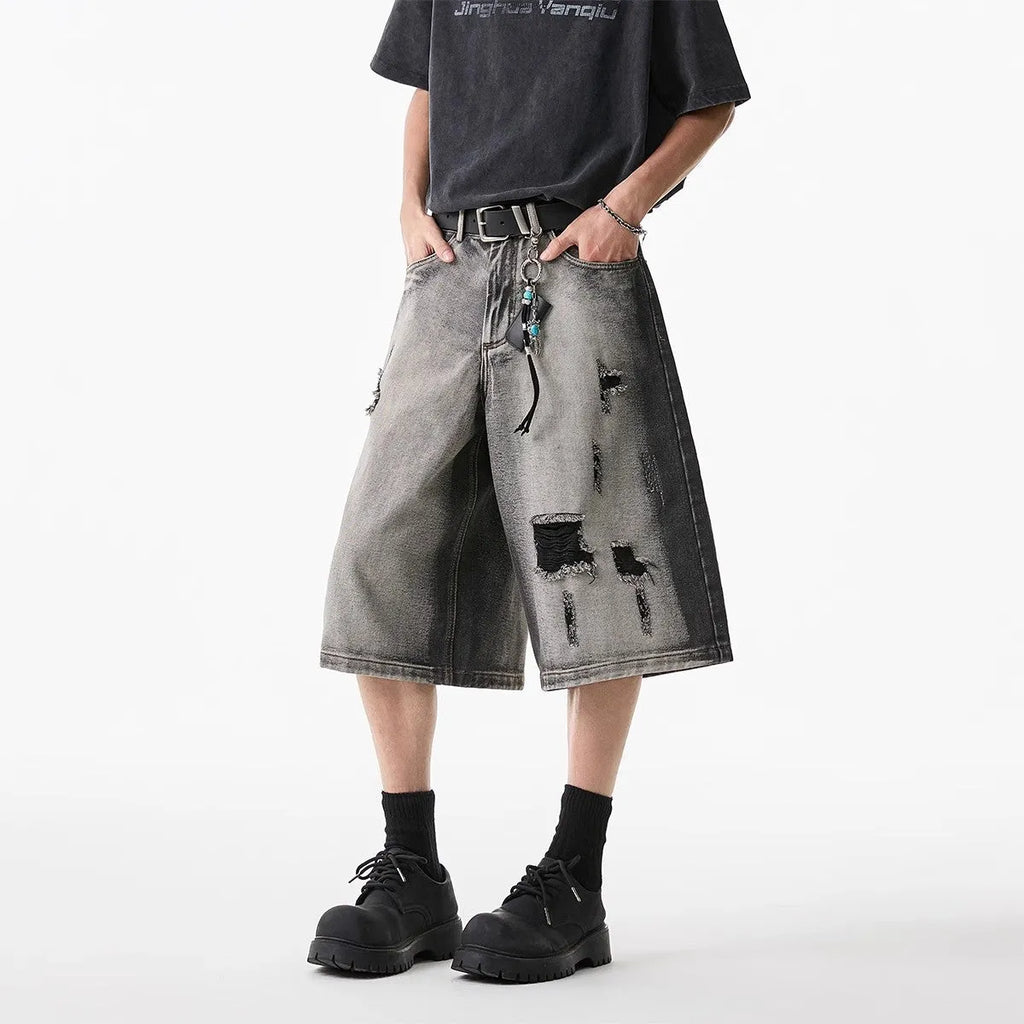 Grey high street washed cotton denim shorts with a loose, cropped fit on a hanger.