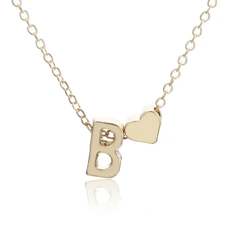 Gold alloy peach heart-shaped pendant with a single letter charm on a silver chain.