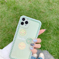 Green TPU iPhone case with geometric smiley face design and polka dot frame on a phone.
