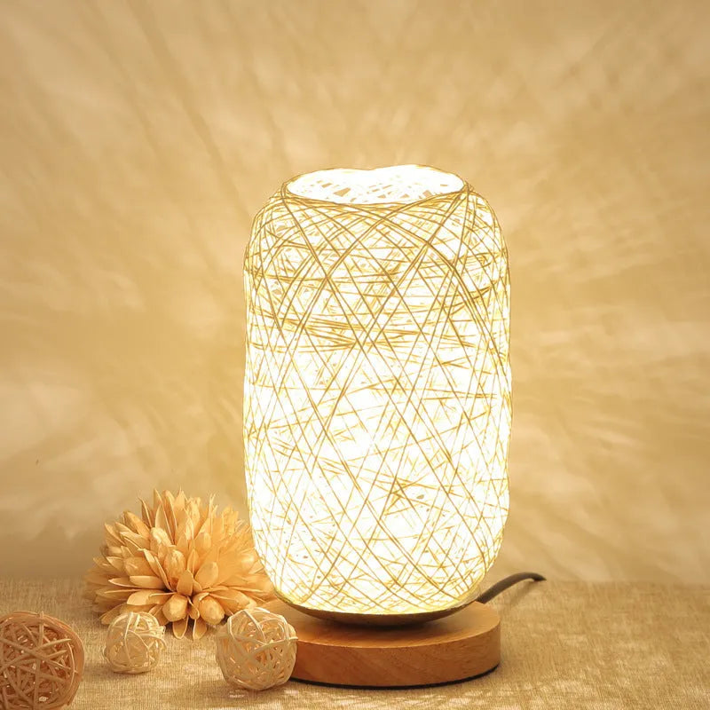 Sepak Takraw ball design desk lamp made of brown hemp rope and wood with a warm LED light.