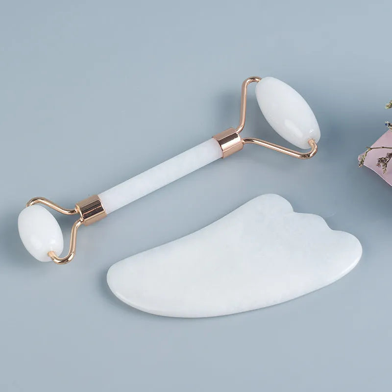 White jade dual-head facial roller and gua sha tool with a separate massage board on a plain background.