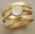 Gold-plated titanium steel ring with hollow geometric design and micro-inlaid white chalcedony.