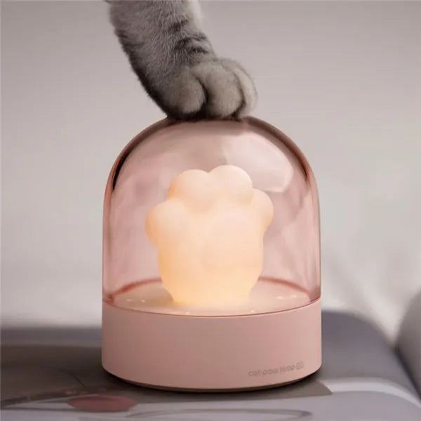 Grey and pink cat paw shaped USB rechargeable night light with music box on a desk