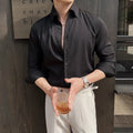 Man wearing a dark striped long sleeve V-neck cardigan shirt in a casual setting.