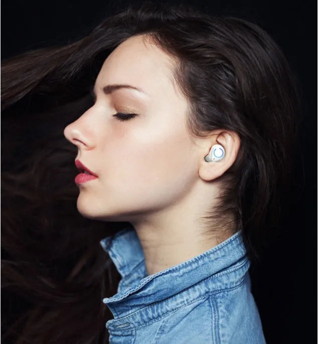 Black and white true wireless in-ear Bluetooth headset with charging case on a plain background.