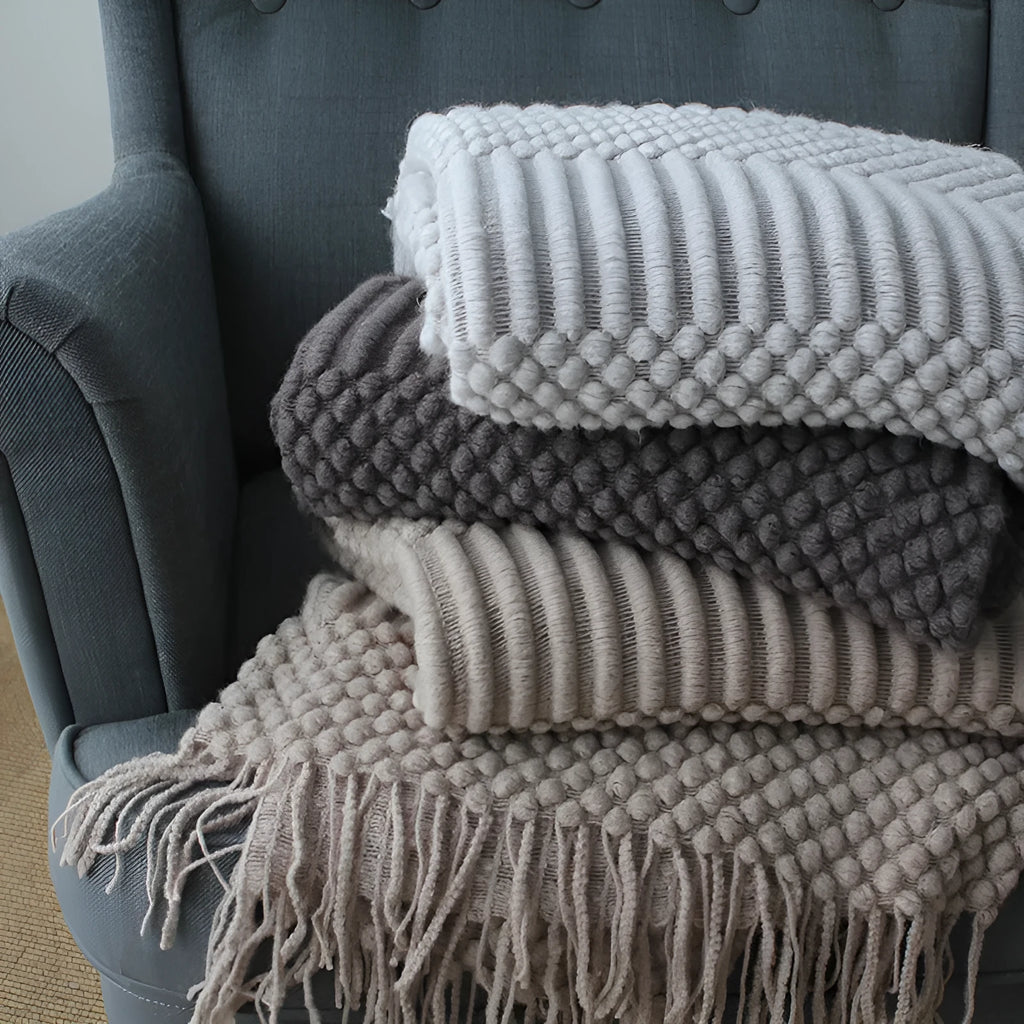 Light grey polyester throw blanket draped over a sofa, showing its size.
