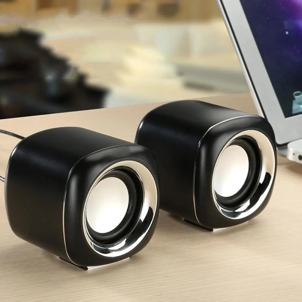 Pair of small black wired desktop computer speakers with volume wheel