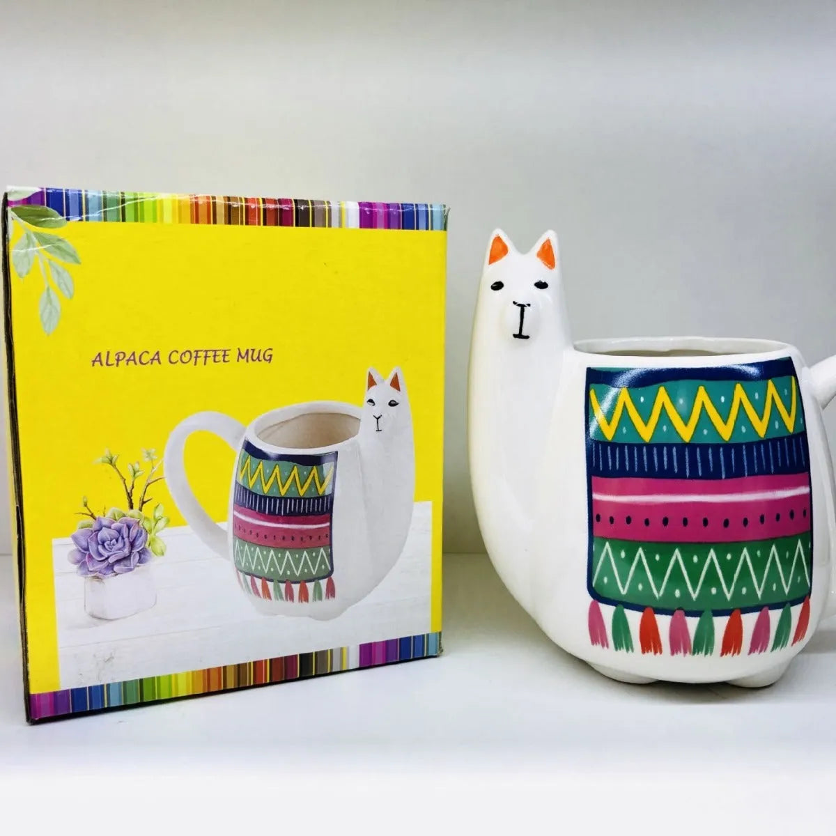 White ceramic mug with handle featuring a cartoon alpaca pattern on the side