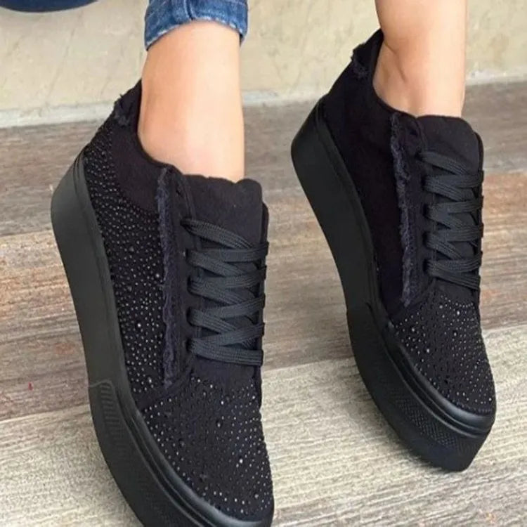 Women's black casual sneakers with rhinestone lace-up detail and a thick flat rubber sole.