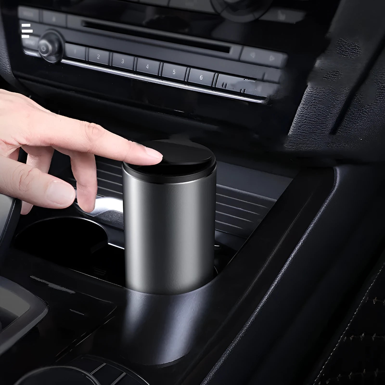 Alloy car trash bin in black with click-open lid placed in cup holder