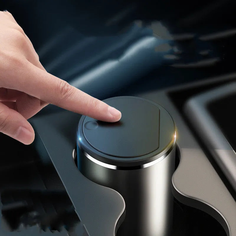 Alloy car trash bin in black with click-open lid placed in cup holder
