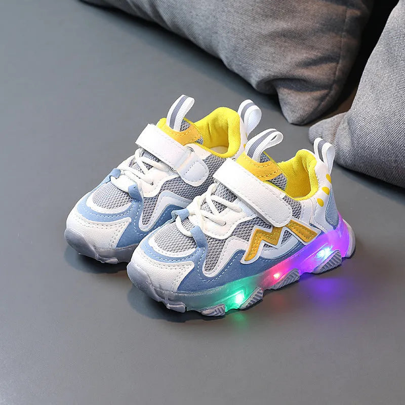 Children's bright coloured sneakers with mesh panels and a Velcro strap fastening, shown in black, pink, and grey.