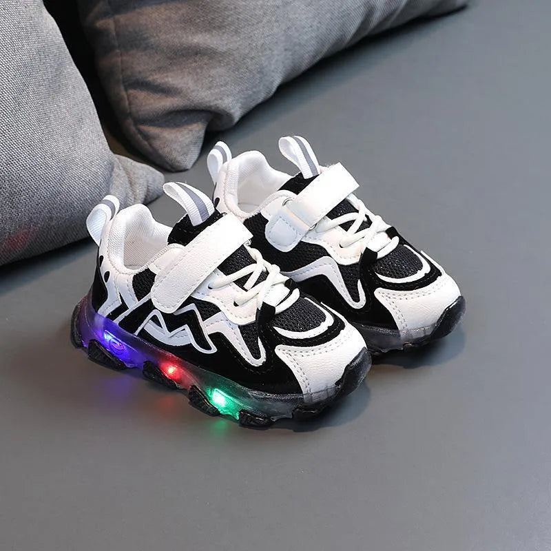 Children's bright coloured sneakers with mesh panels and a Velcro strap fastening, shown in black, pink, and grey.