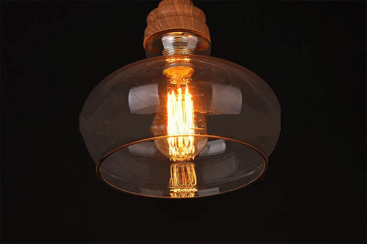 Glass single head pendant light with wood grain finish and adjustable height mechanism