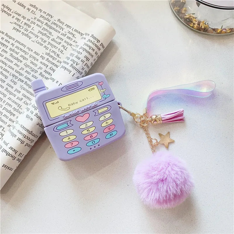 Purple silicone clamshell case for Apple AirPods with a small fur ball pendant attached.