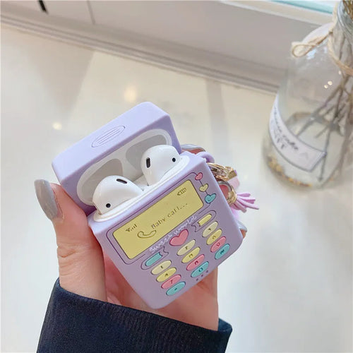 Purple silicone clamshell case for Apple AirPods with a small fur ball pendant attached.