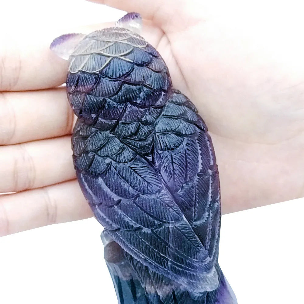 Purple fluorite hand-carved night owl ornament on display surface showing detailed carving