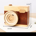 Wooden camera-shaped music box in sanded pine finish, shown in large and small size options.