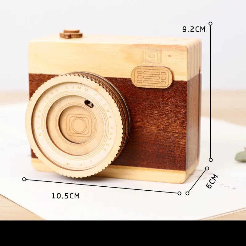 Wooden camera-shaped music box in sanded pine finish, shown in large and small size options.