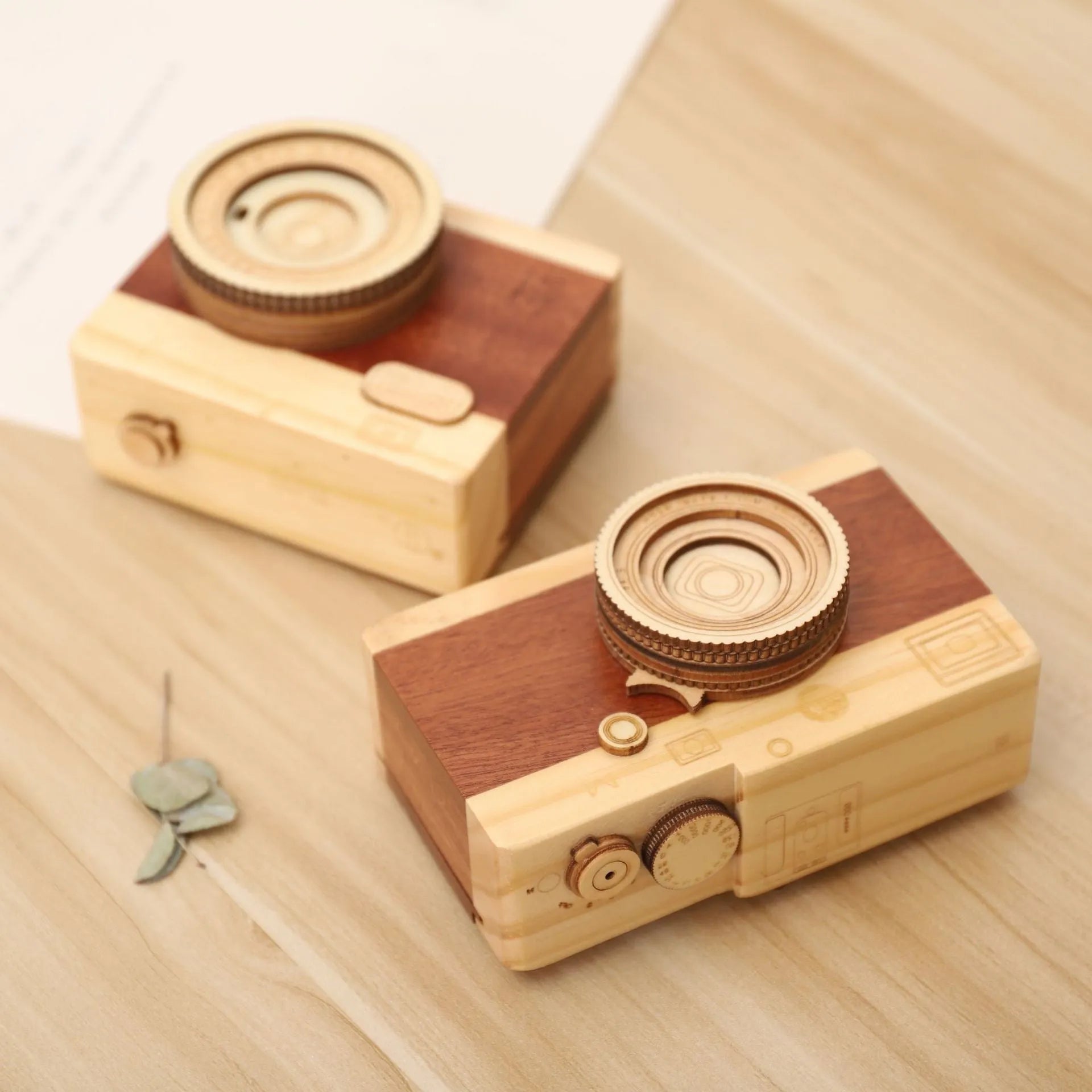 Wooden camera-shaped music box in sanded pine finish, shown in large and small size options.