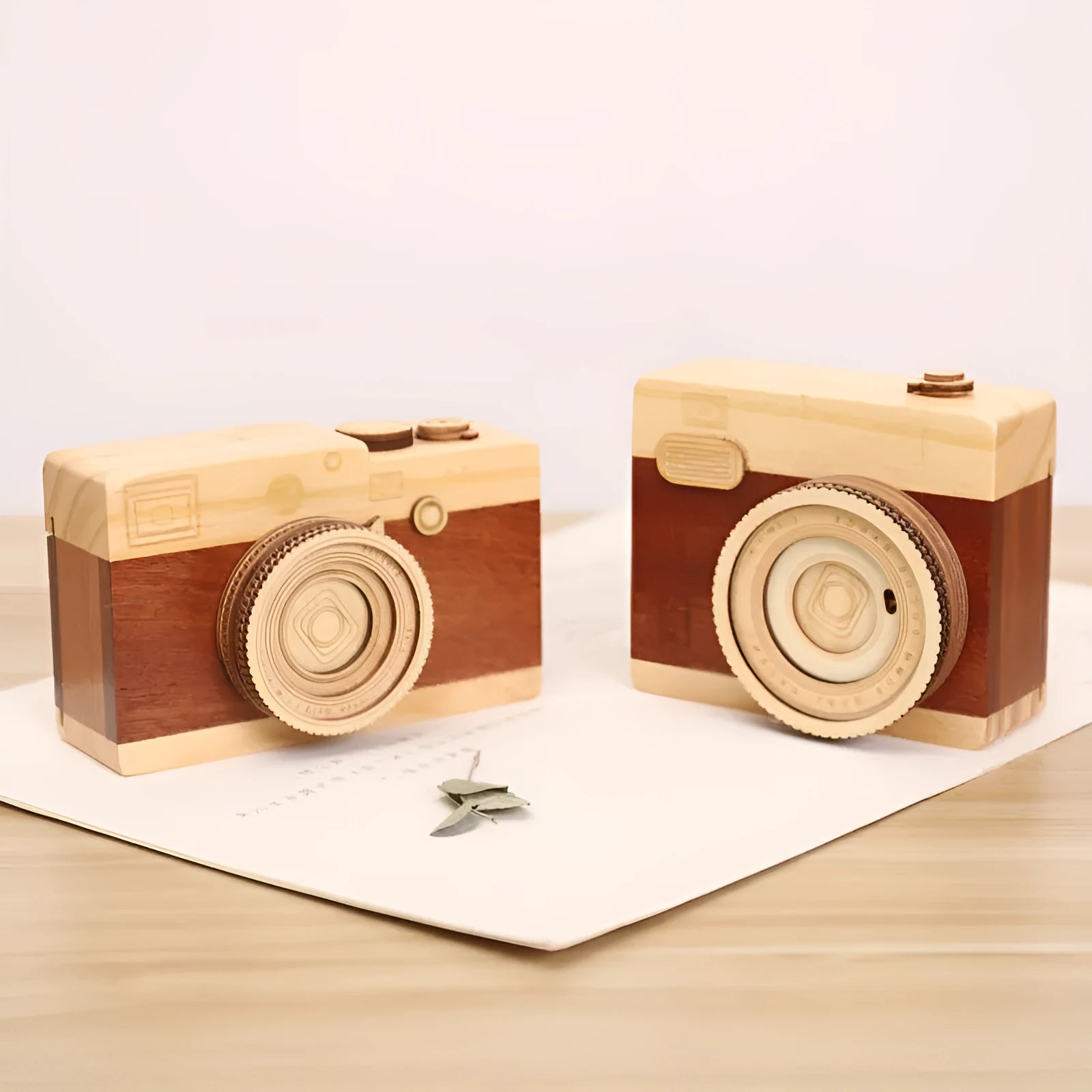 Wooden camera-shaped music box in sanded pine finish, shown in large and small size options.