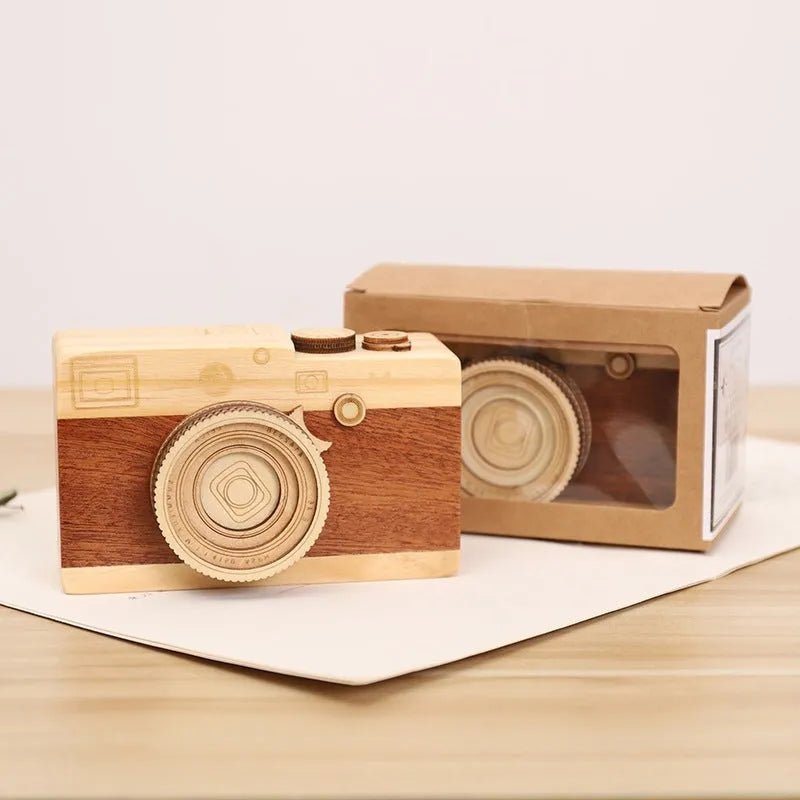 Wooden camera-shaped music box in sanded pine finish, shown in large and small size options.