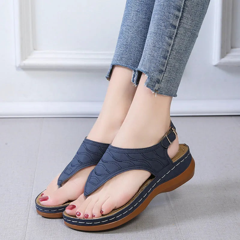 Women's wedge heel flip flop sandals with an adjustable back buckle strap in black.