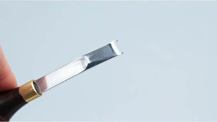 Sectional wide shovel edge thinning knife with leather handle for tool maintenance.