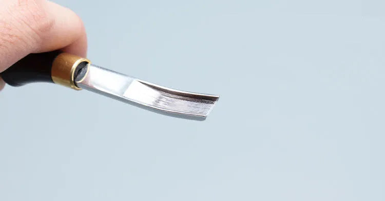 Sectional wide shovel edge thinning knife with leather handle for tool maintenance.
